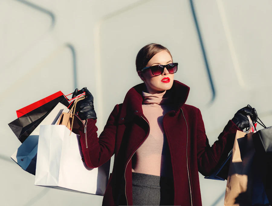 Woman in a burgundy coat holding shopping bags