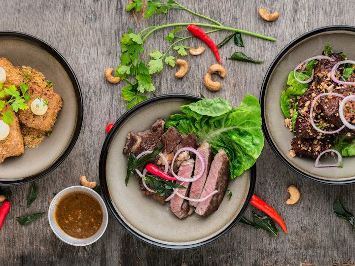 Plates of grilled food with salad and chillies